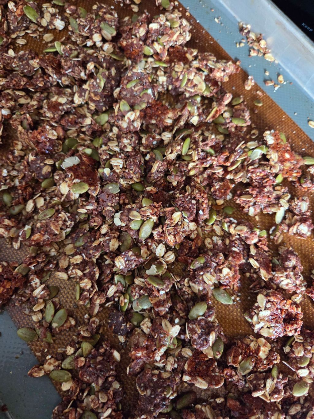 chocolate protein granola on baking sheet
