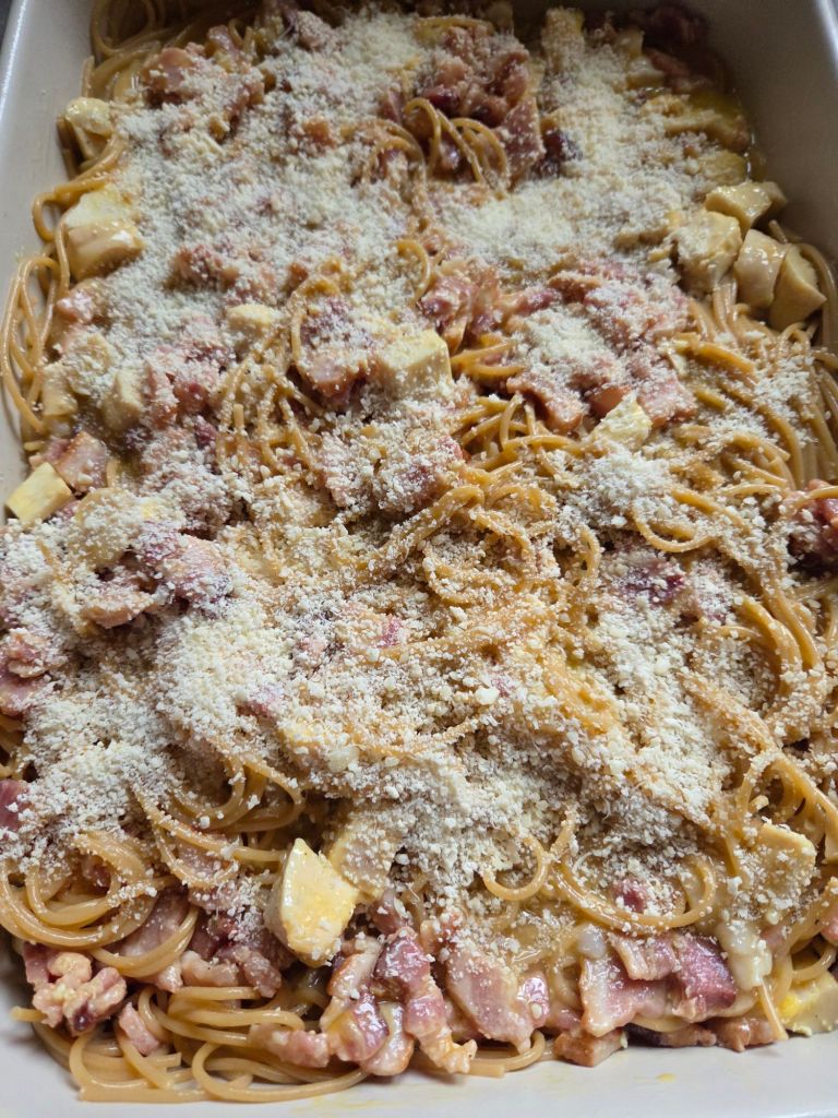 Grated Parmesan cheese sprinkled over the top of noodles and sauce 